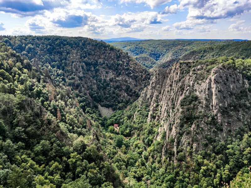 The wooded cliffs of the Bode valley in the Harz, under a summer sky